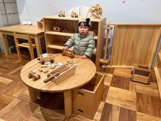 なかよしライブラリー吉祥寺店店内　丸テーブルで動物バスを走らせて遊ぶ男の子