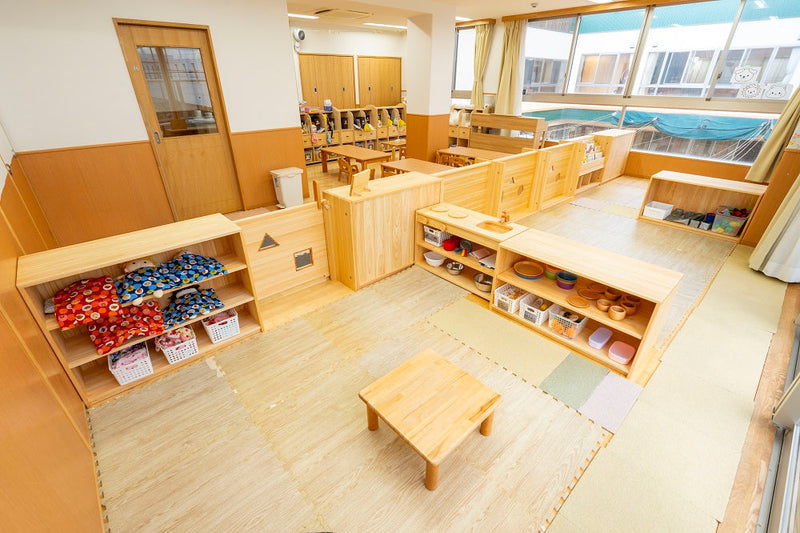 【1〜2歳児室】開明かしの木こども園様：兵庫県産ヒノキ材の保育家具の導入。色の統一感と遊びのメリハリを両立した環境改善事例