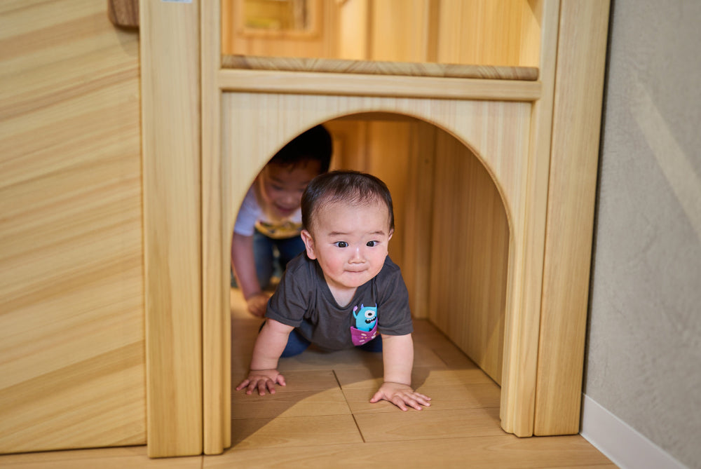 子どもがアスレチック滑り台のトンネルをくぐる様子