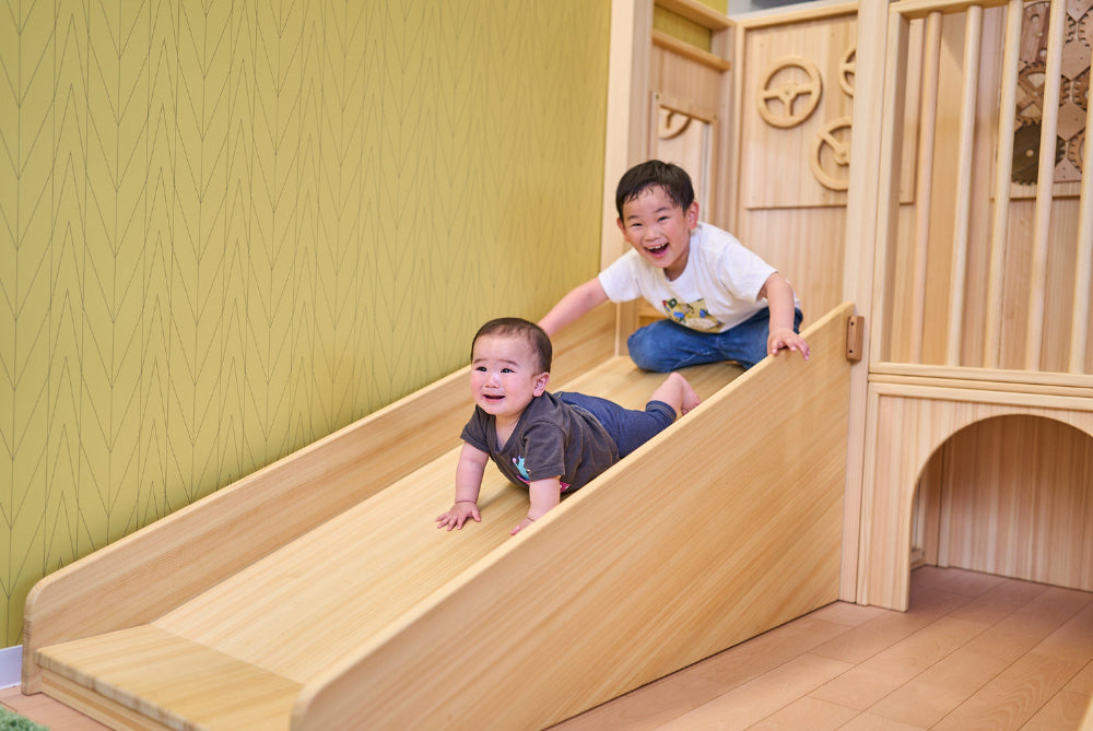 子どもがアスレチック滑り台を滑る様子